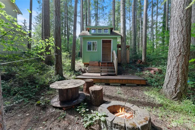 a view of a chair and table in backyard of the house