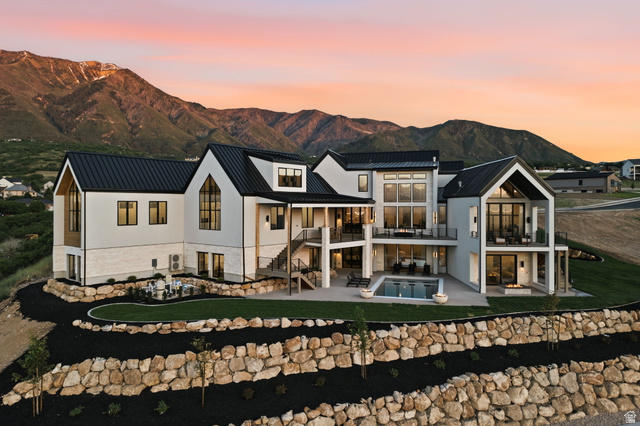 923 North Emery Lane Elk Ridge, UT 84651 - Photo 96 of 101 Contemporary architectural design featuring expansive glass, multiple balconies, a lower-level patio with a swimming pool, and tiered landscaping