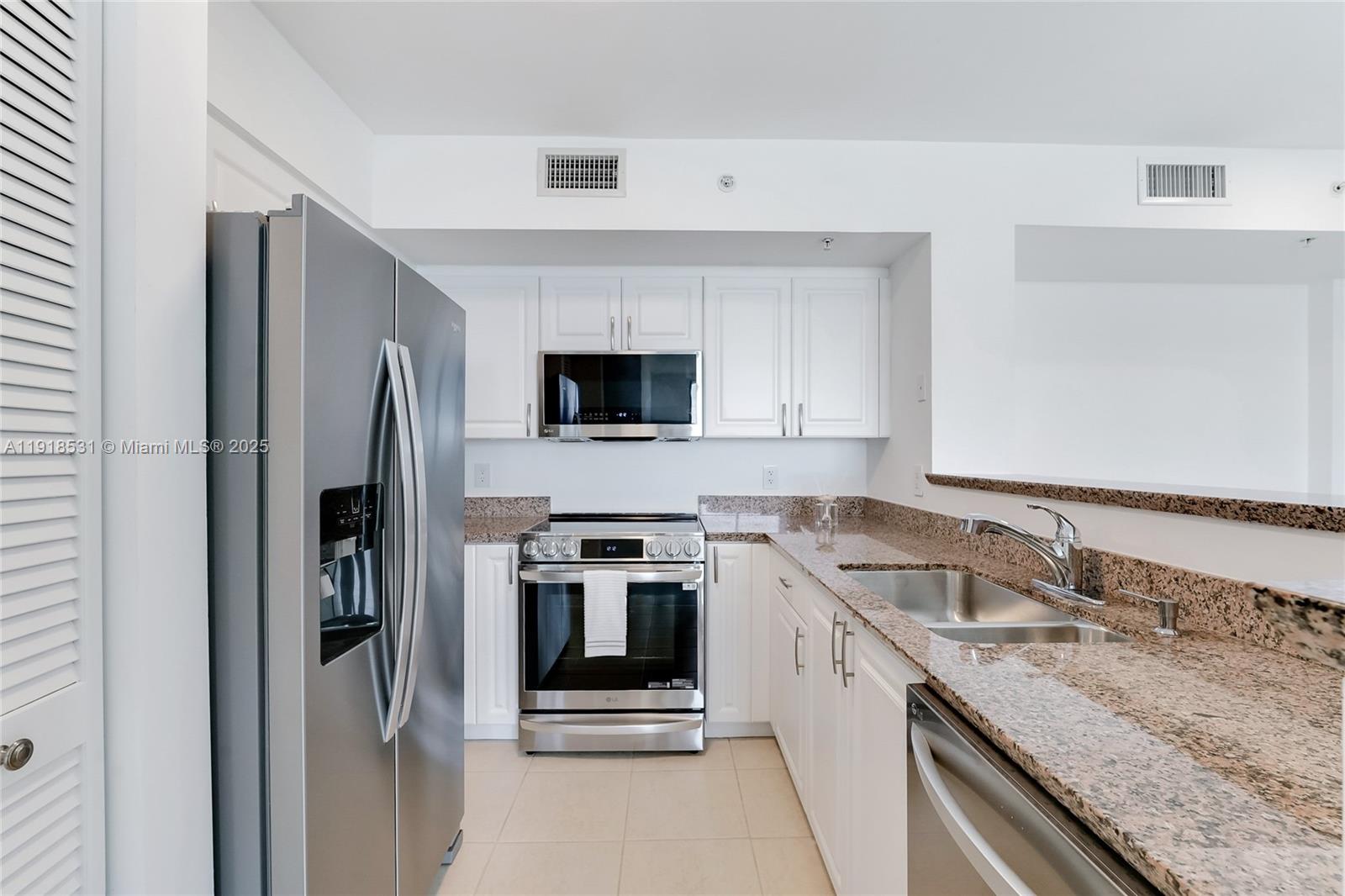 90 Alton Road, Unit 1209 Miami Beach, FL 33139 - Photo 30 of 44 a kitchen with a sink stove and refrigerator