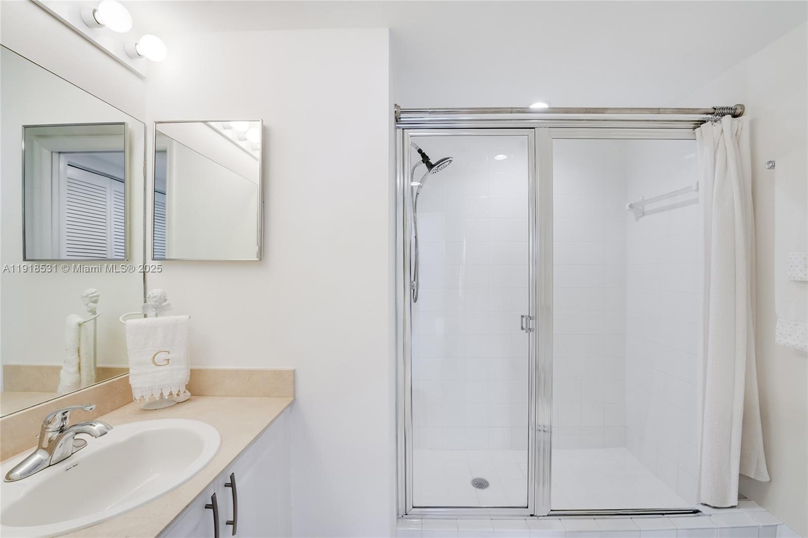 90 Alton Road, Unit 1209 Miami Beach, FL 33139 - Photo 37 of 44 a bathroom with a shower sink and vanity