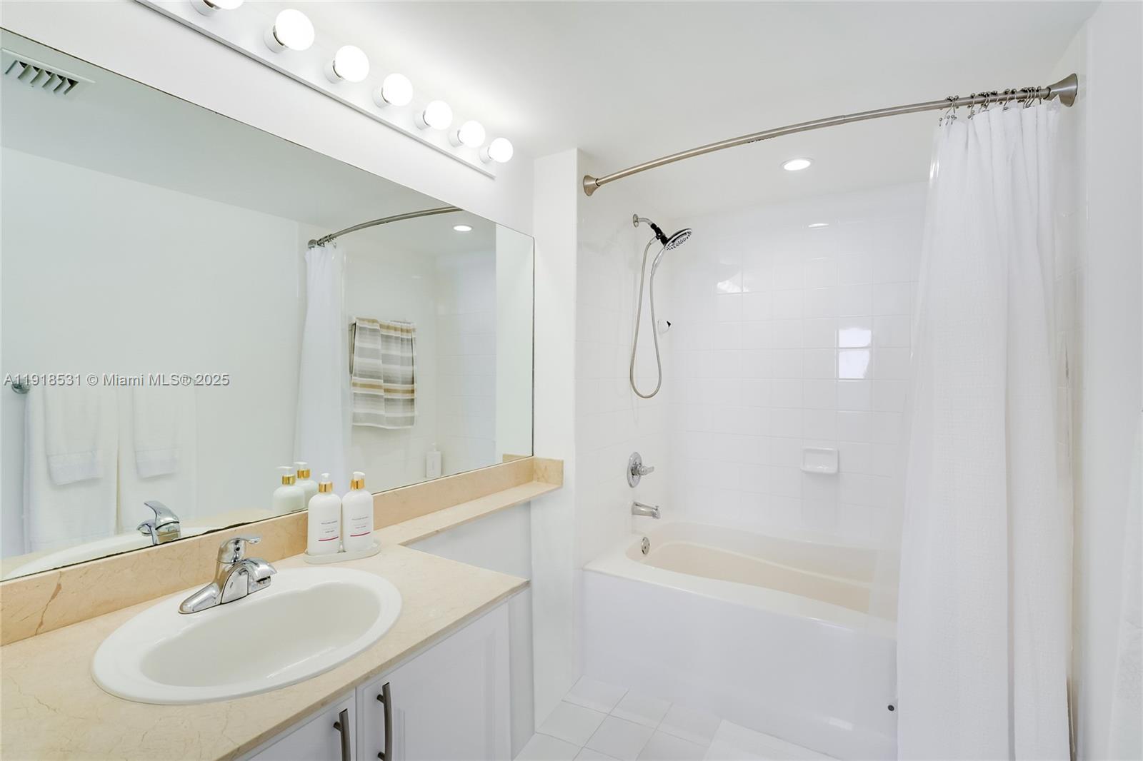 90 Alton Road, Unit 1209 Miami Beach, FL 33139 - Photo 43 of 44 a bathroom with a sink shower and a mirror