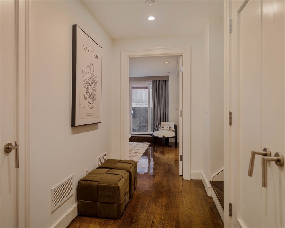 92 Waltham Street, Unit 1A Boston, MA 02118 - Photo 31 of 41 a hallway with a couch and a dresser with wooden floor