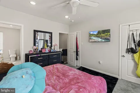 a bedroom with a bed and a mirror on dresser