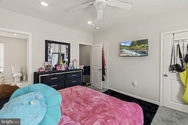 a bedroom with a bed and a mirror on dresser