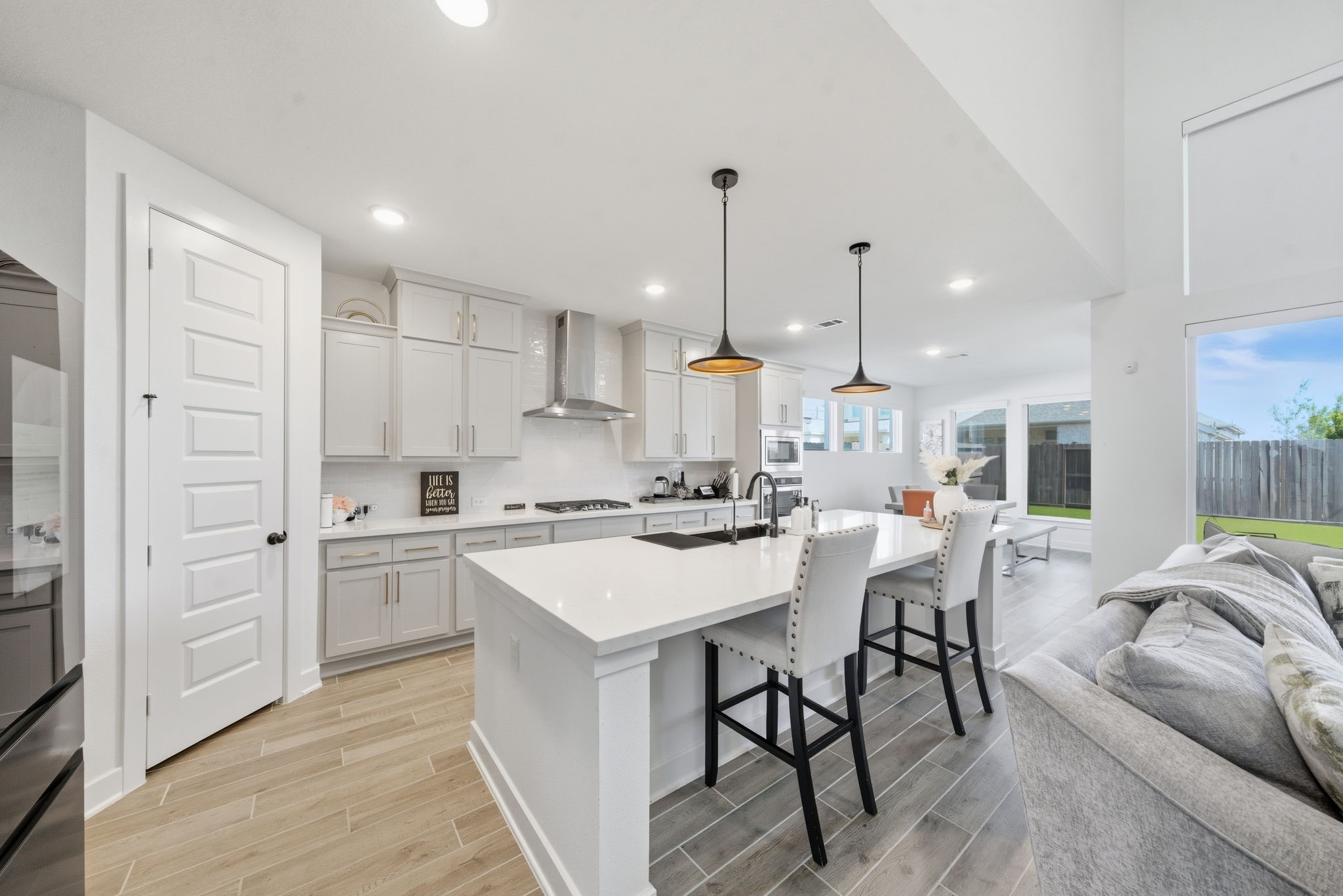 10438 Rigel Rdg Way Richmond, TX 77406 - Photo 11 of 34 a kitchen with stainless steel appliances kitchen island granite countertop a stove a sink a refrigerator and white cabinets with wooden floor