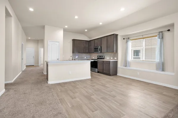 a kitchen with sink a microwave a stove and cabinets