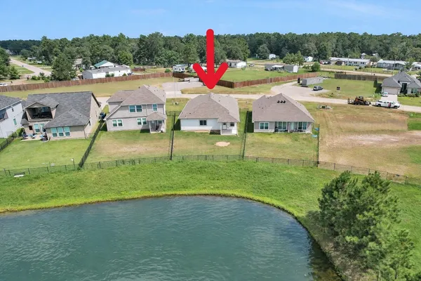 an aerial view of a house with a yard and lake view