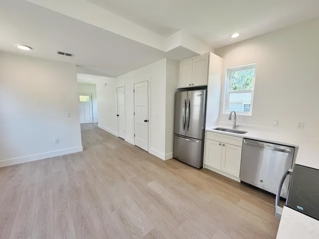 a view of a kitchen with a sink stove and cabinet