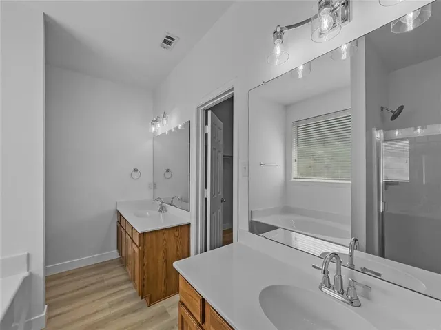 a view of a room with wooden floor and a ceiling fan