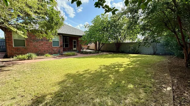 a view of a patio with table and chairs next to a yard