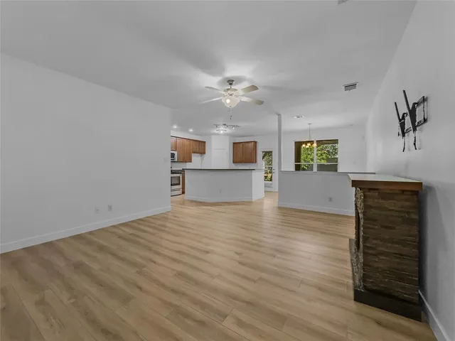 wooden floor in an empty room with a kitchen