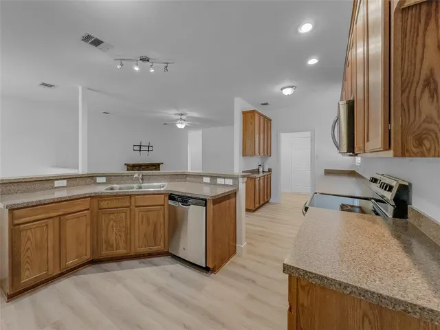 a kitchen with a sink cabinets and wooden floor