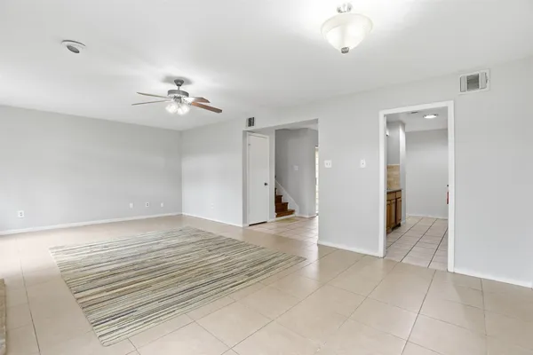 a view of an empty room with a chandelier fan