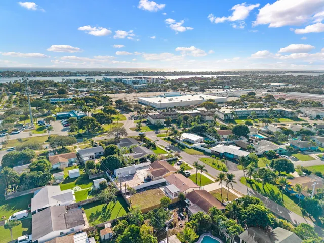 an aerial view of residential houses with outdoor space and trees