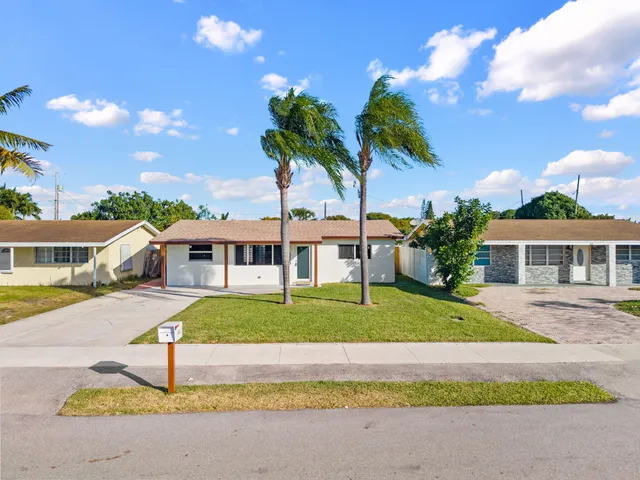 a house with palm tree in front of it