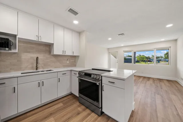 a kitchen with a stove sink and cabinets