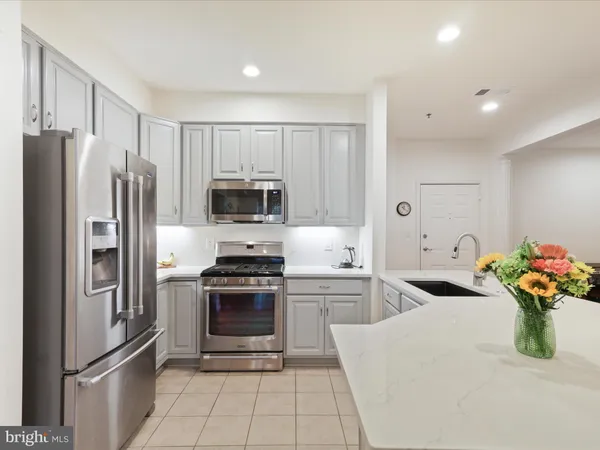 a kitchen with stainless steel appliances a refrigerator sink and microwave