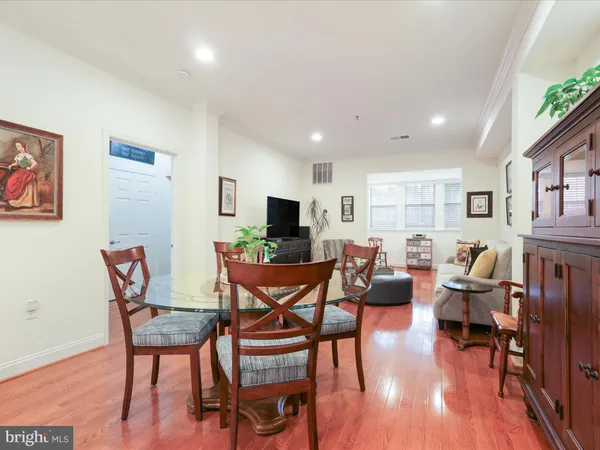 a living room with furniture a wooden floor and a flat screen tv