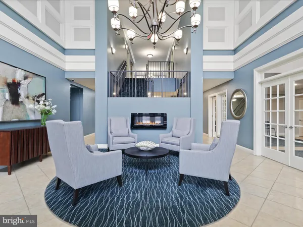 a living room with furniture a fireplace and a chandelier