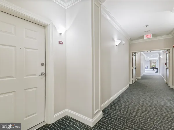 a view of a hallway with a livingroom and a bathroom with sink