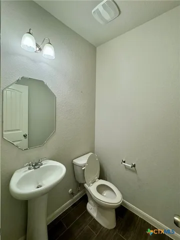 a bathroom with a toilet sink and mirror