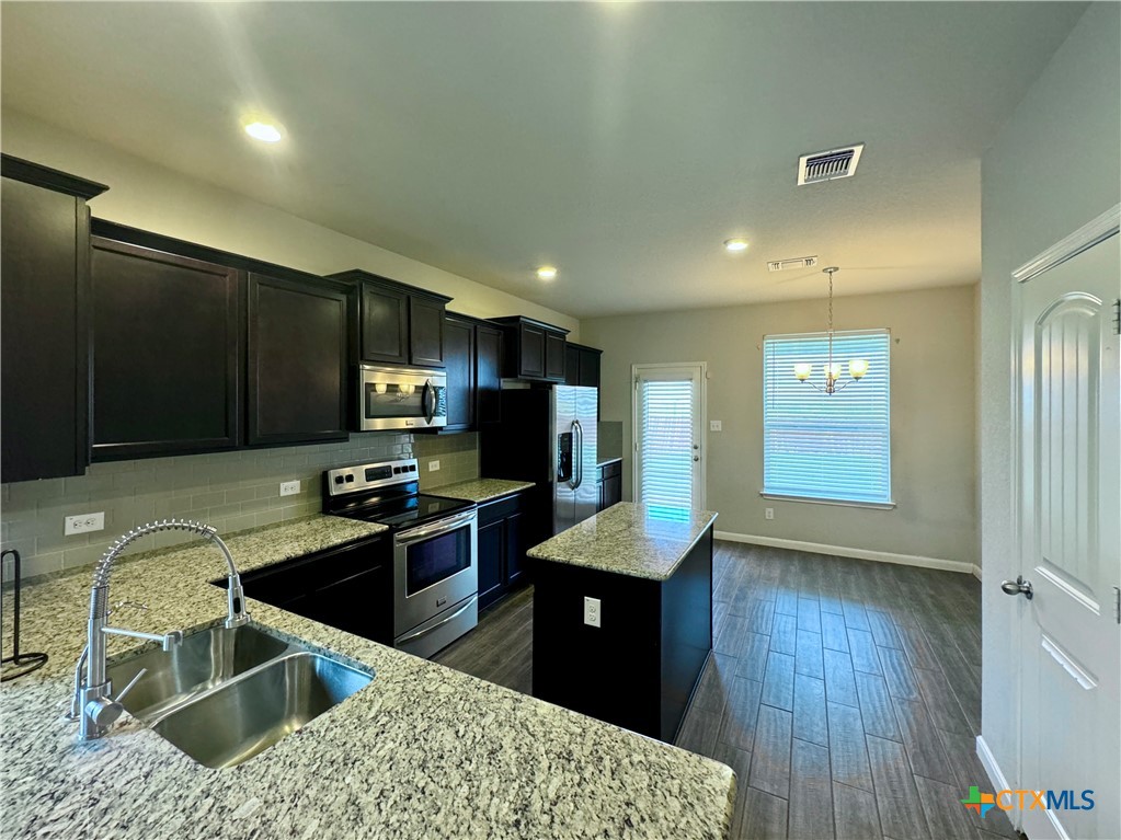 942 Pumpkin Ridge New Braunfels, TX 78130 - Photo 4 of 18 a kitchen with stainless steel appliances kitchen island granite countertop a sink stove and refrigerator