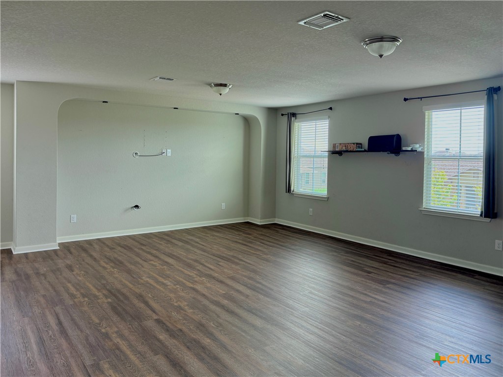 942 Pumpkin Ridge New Braunfels, TX 78130 - Photo 7 of 18 an empty room with wooden floor and windows