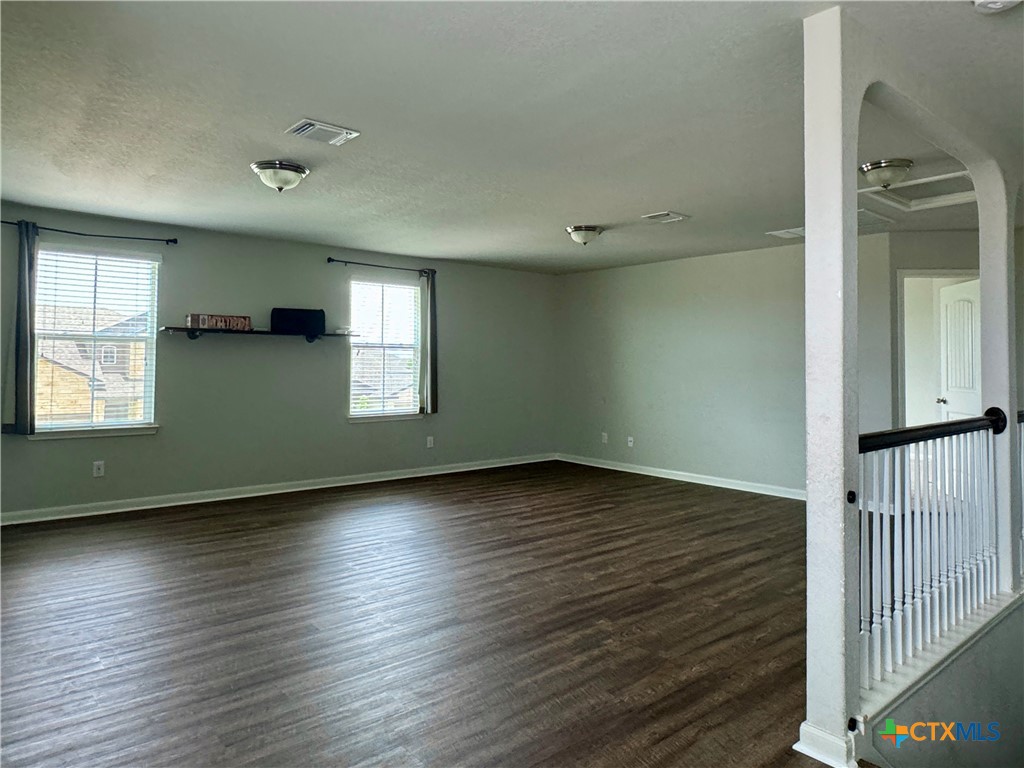 942 Pumpkin Ridge New Braunfels, TX 78130 - Photo 8 of 18 an empty room with wooden floor and windows
