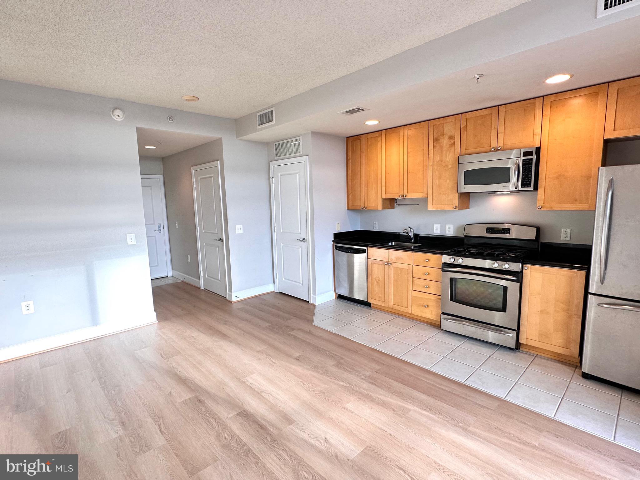 a kitchen with stainless steel appliances granite countertop a stove and a refrigerator