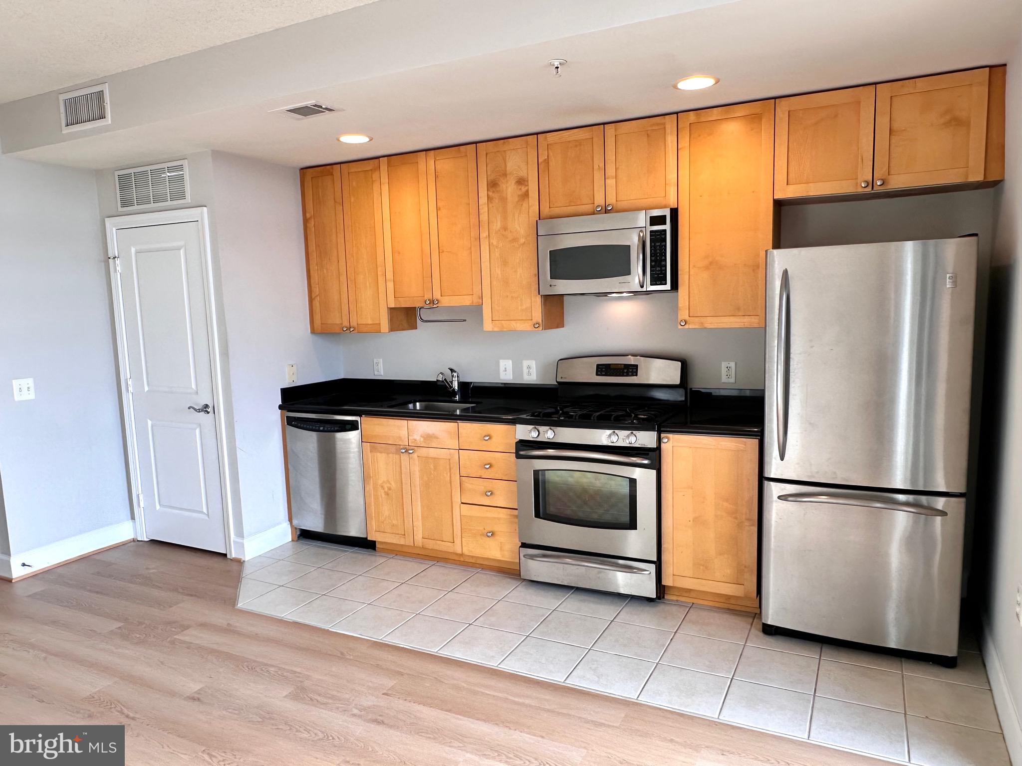 3600 South Glebe Road, Unit 507W Arlington, VA 22202 - Photo 3 of 23 a kitchen with stainless steel appliances granite countertop a refrigerator a stove a sink and a microwave