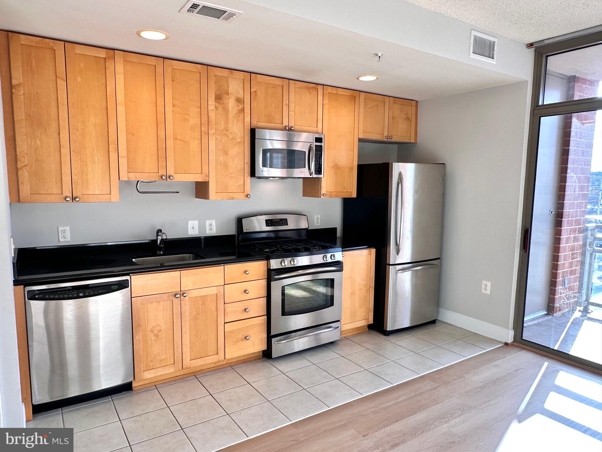 3600 South Glebe Road, Unit 507W Arlington, VA 22202 - Photo 4 of 23 a kitchen with stainless steel appliances granite countertop a refrigerator a sink and white cabinets