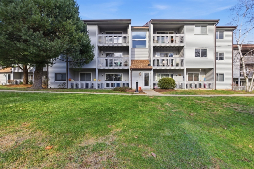 2211 Franklin Crossing Road, Unit 2211 Franklin, MA 02038 - Photo 21 of 32 a front view of a building with a garden and trees