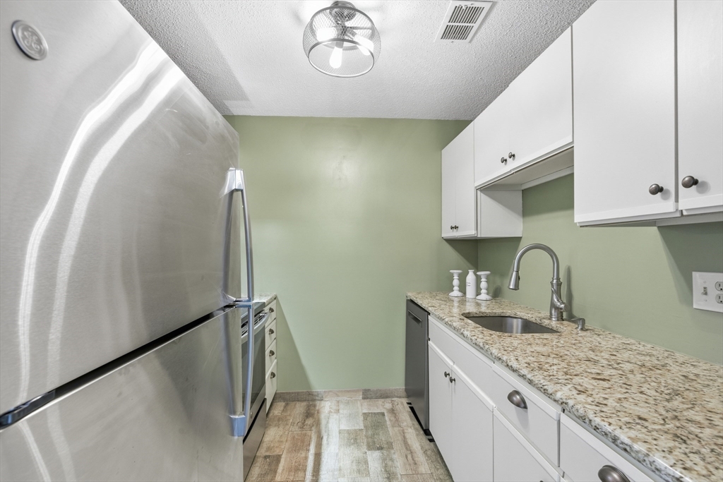 2211 Franklin Crossing Road, Unit 2211 Franklin, MA 02038 - Photo 8 of 32 a kitchen with a sink a refrigerator and cabinets