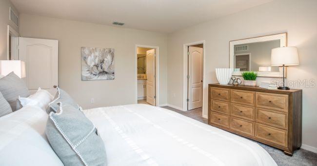 5268 Hanford Avenue Spring Hill, FL 34608 - Photo 9 of 14 a large bedroom with a bed and a mirror on dresser