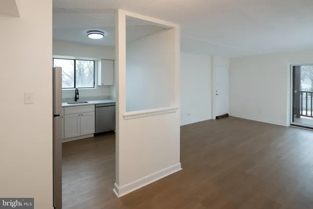 an empty room with windows and sink