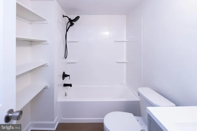 a bathroom with a toilet and a bath tub