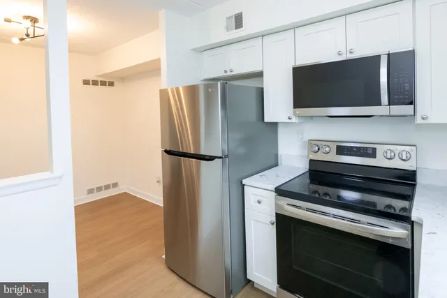 a view of kitchen with stainless steel appliances and refrigerator