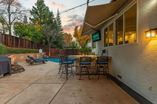 a kitchen with stainless steel appliances granite countertop a stove top oven a sink a refrigerator white cabinets and wooden floor