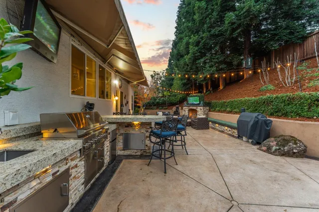 a kitchen with granite countertop a stove a sink and wooden cabinets