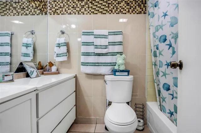 a bathroom with a toilet a sink and a shower curtain
