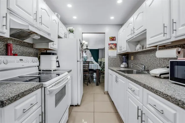 a kitchen with granite countertop a sink stainless steel appliances and cabinets