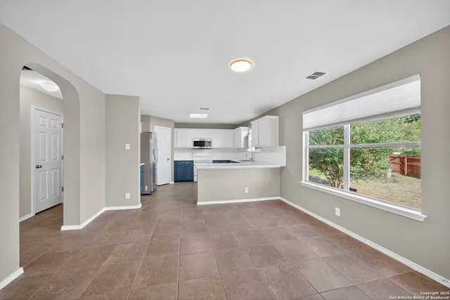 a view of a kitchen with refrigerator and window