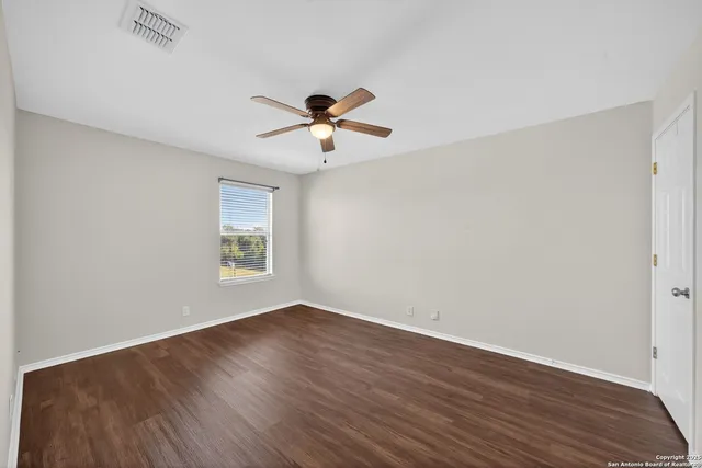 a view of room with hardwood floor and ceiling fan