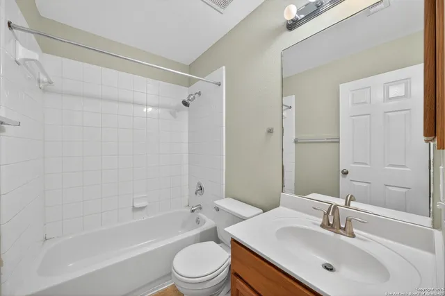 a bathroom with a bathtub shower sink vanity mirror and toilet