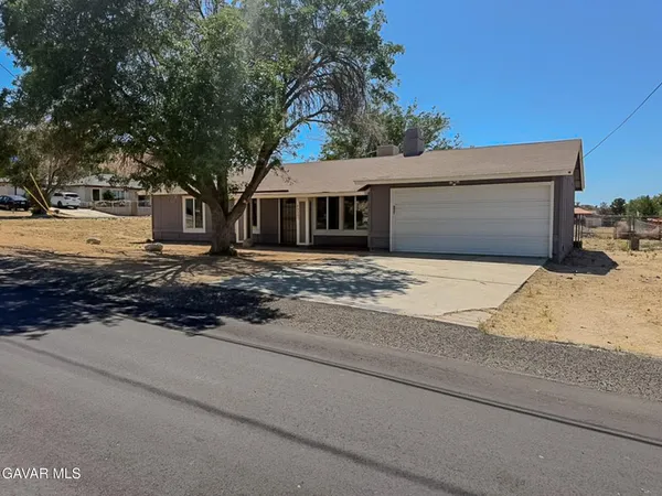 a front view of house with yard and trees