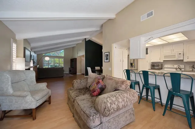 a living room with furniture and a dining table with kitchen view