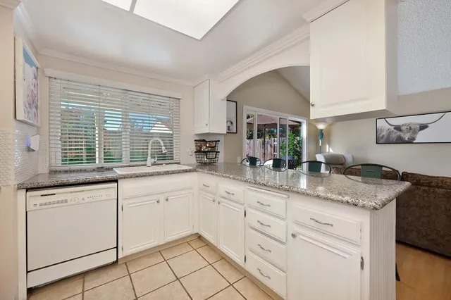a kitchen with granite countertop white cabinets and white appliances