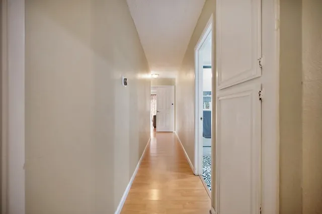 a view of a hallway with wooden floor