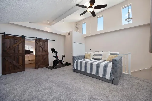 a bed room with a bed and a ceiling fan