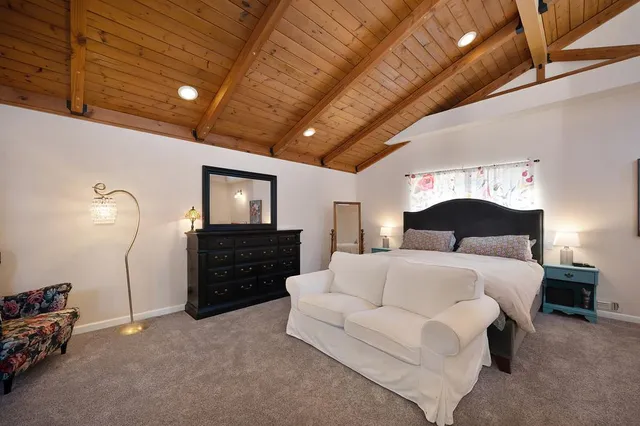 a spacious bedroom with a bed and a chandelier